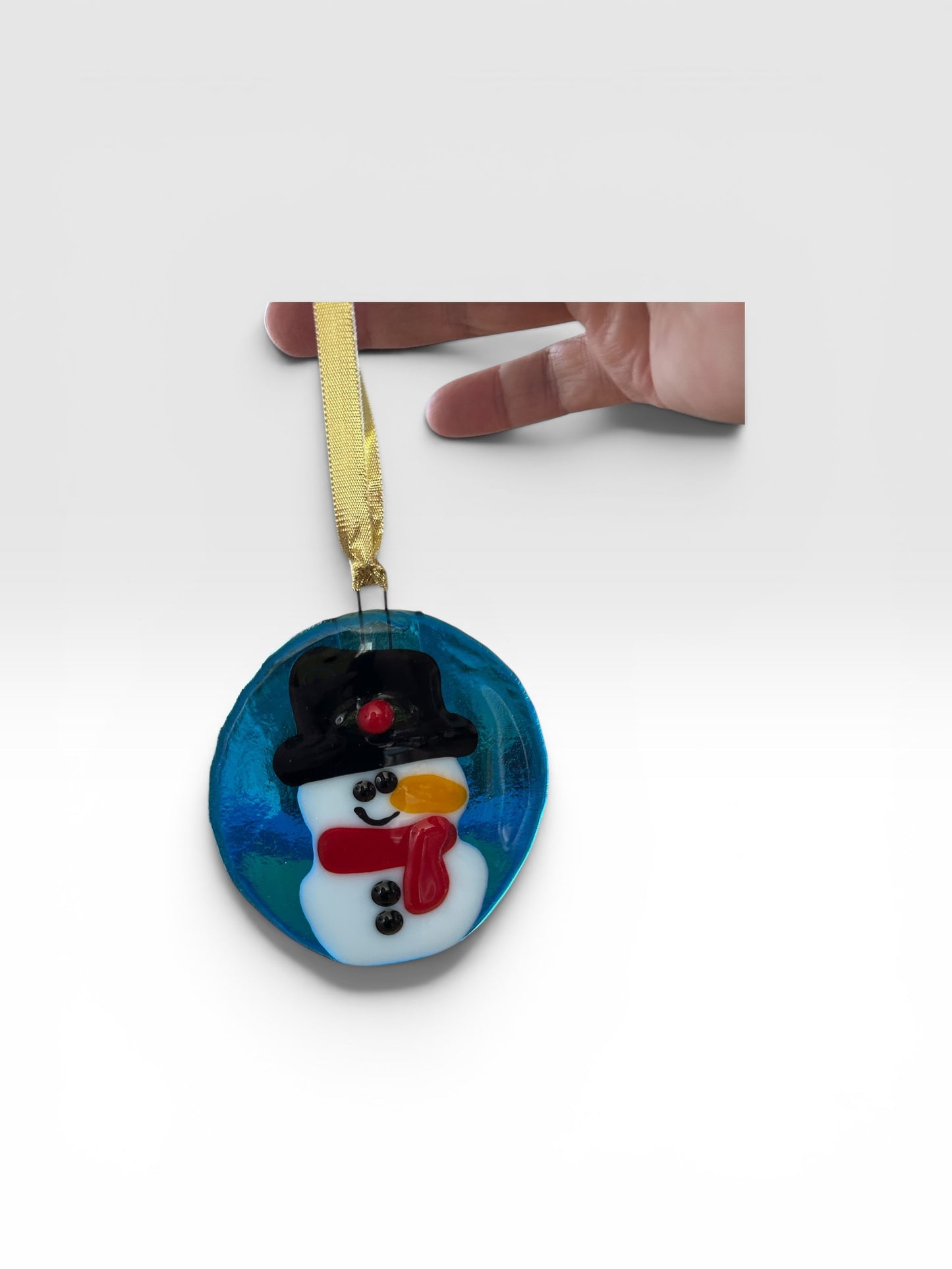 Homemade Fused Glass Snowman Ornament on Blue Background