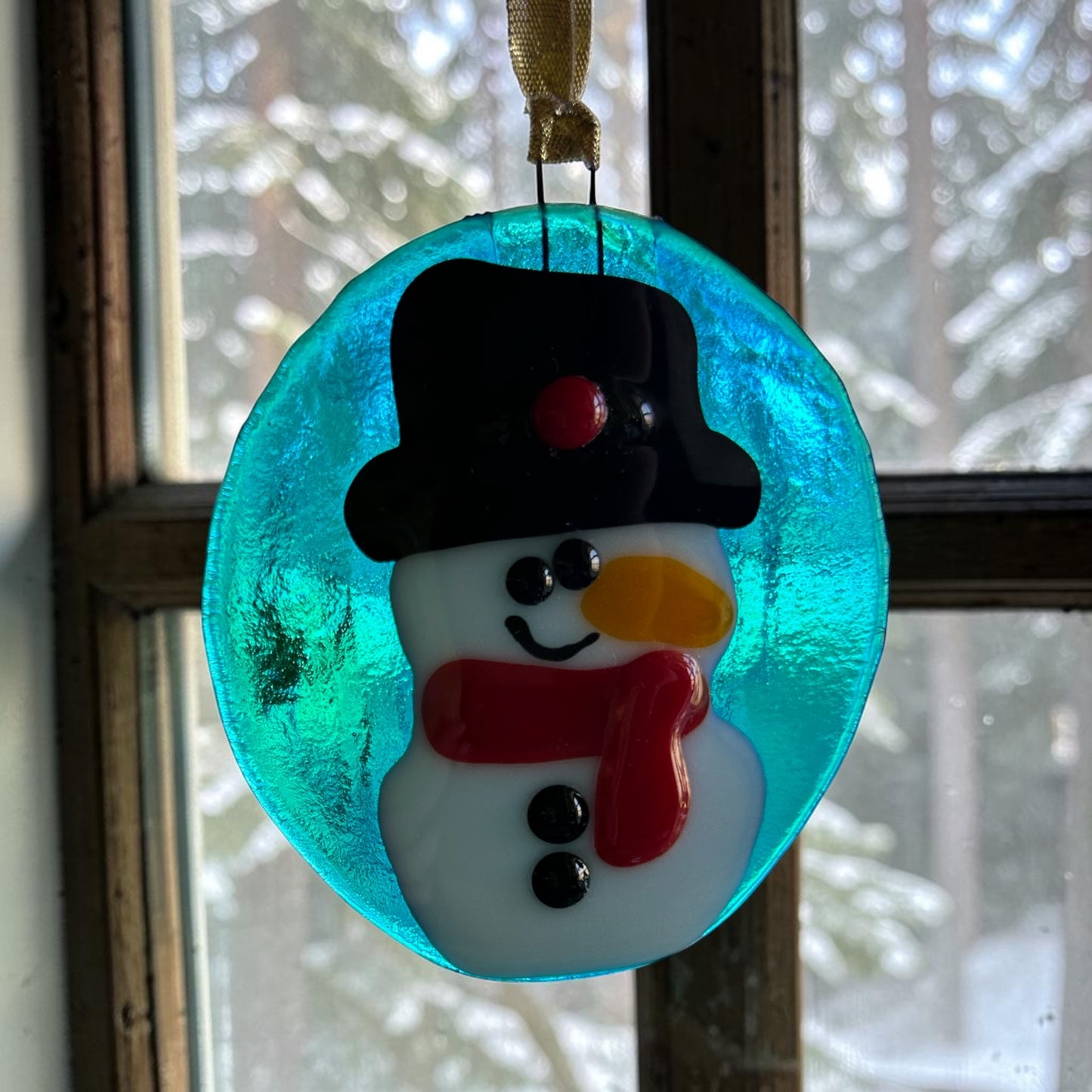 Homemade Fused Glass Snowman Ornament on Blue Background